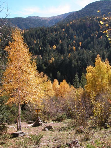 Les couleurs d'automne et le cairn surmonté d'un panneau.
