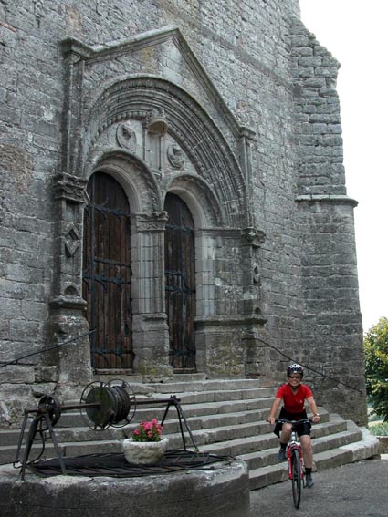 Le portail de l'église, avec un puits au premier plan.
