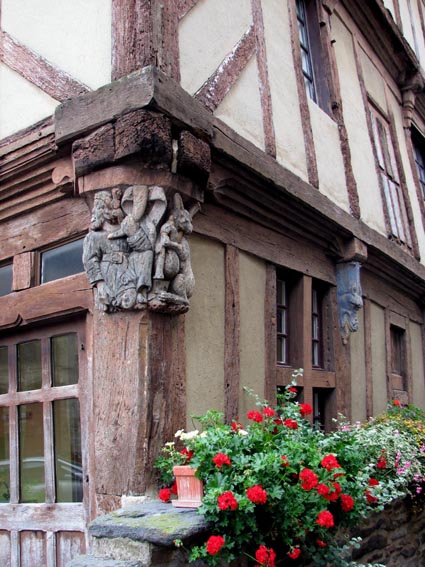 Maison de la Truie qui file: un chasseur soufflant dans un cor, et un livre jouant du biniou.