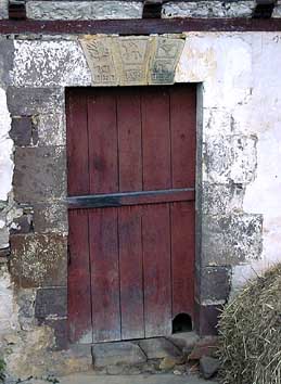 Porte de la ferme ci-contre, datant de 1693. Remarquer en bas "gatu xilo": le trou du chat...