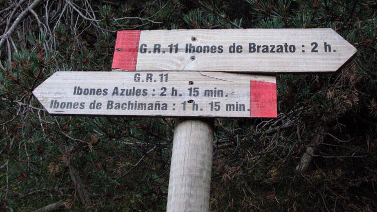 Un panneau bois indique "Ibones de Brazato" à 2H00 sur la droite