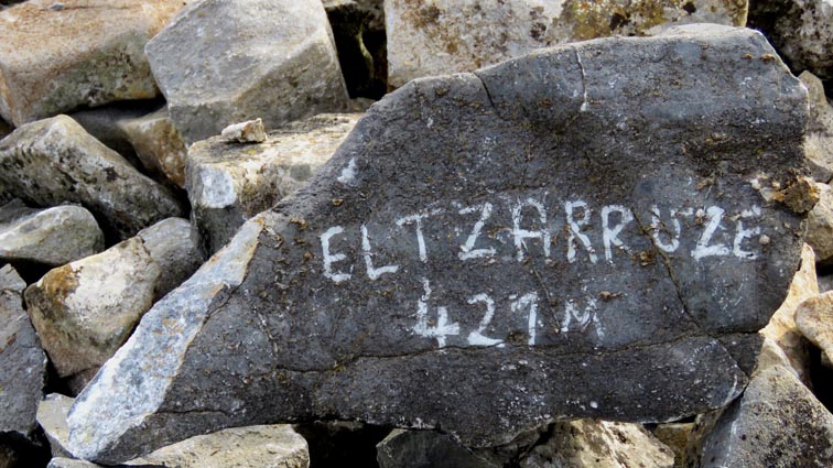 Une pierre porte la mention "Eltzarruze 421m", peinte en blanc sur une pierre.