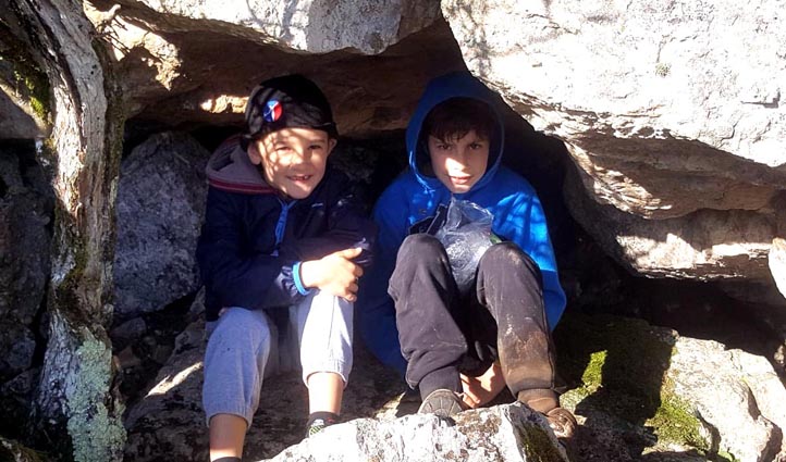 Les garçons se nichent dans une grotte pour manger.