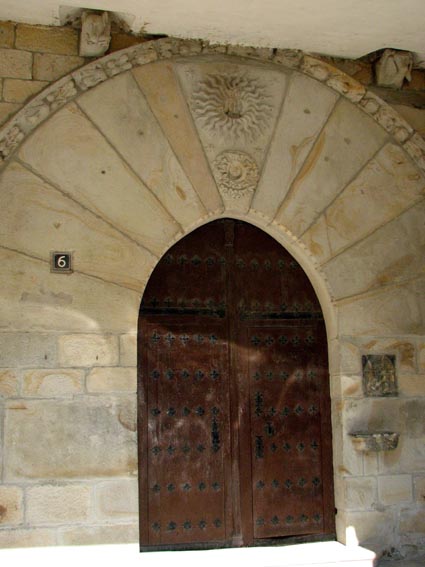 Le portail situé sous le couvert de la façade Sud est magnifiquement surmonté d'un soleil et d'une lune.