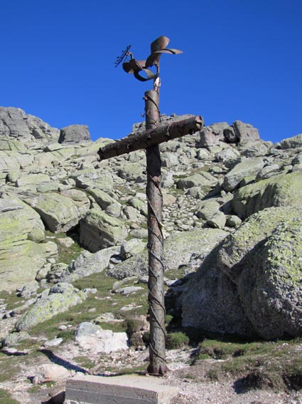 Une croix métallique surmontée d'un oiseau en ferraille.